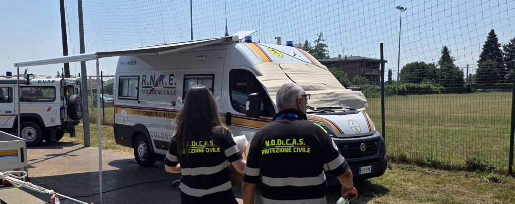 Operatori NODICAS, di spalle camminano verso il furgone sala operativa mobile, modulo tlc di RNRE